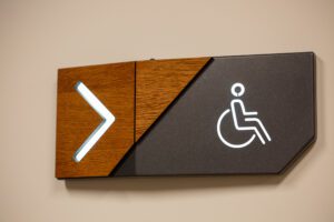 A directional sign pointing right with a wheelchair accessibility symbol.