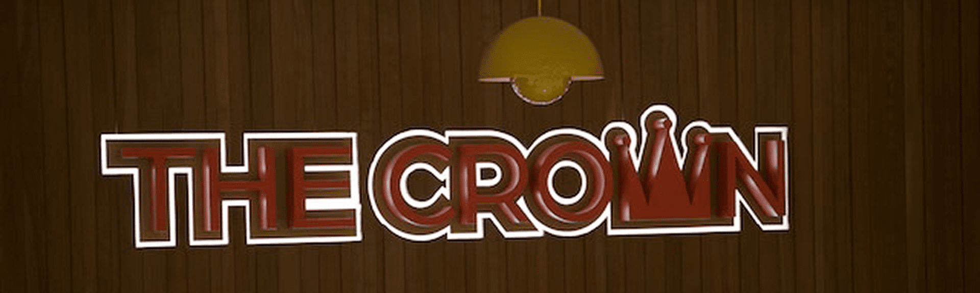 Close-up of illuminated 'LE CROI' sign on wooden wall under a yellow lamp.