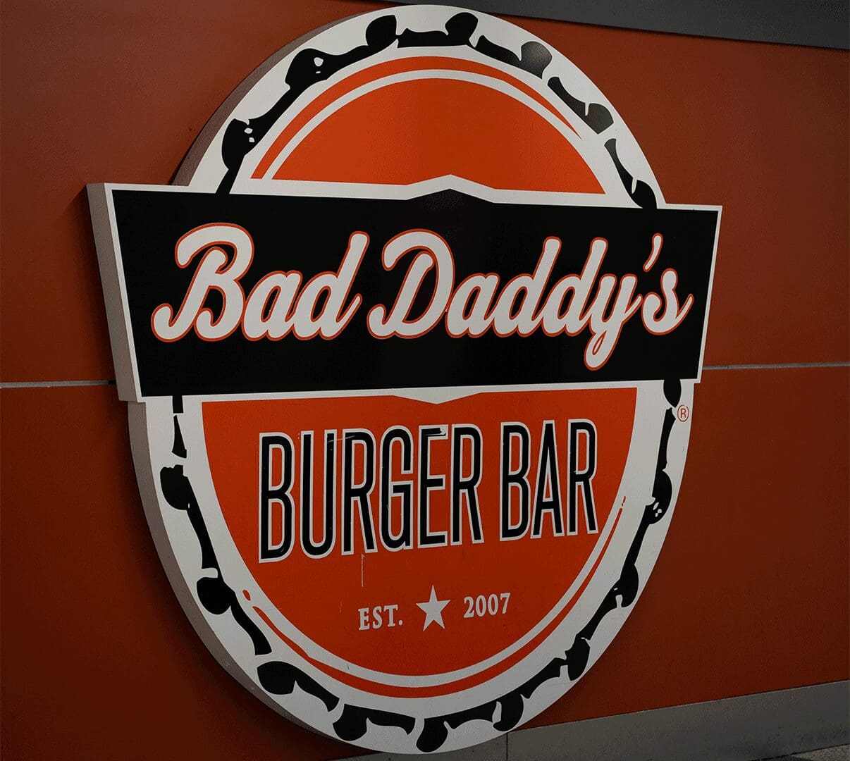 Circular orange Bad Daddy's Burger Bar sign