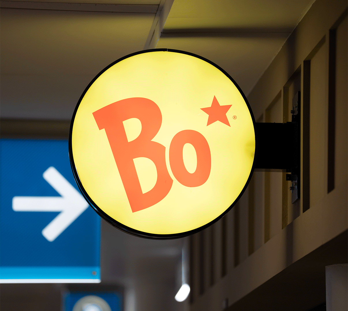A round yellow sign with 'Bo' and a red star in a hallway.