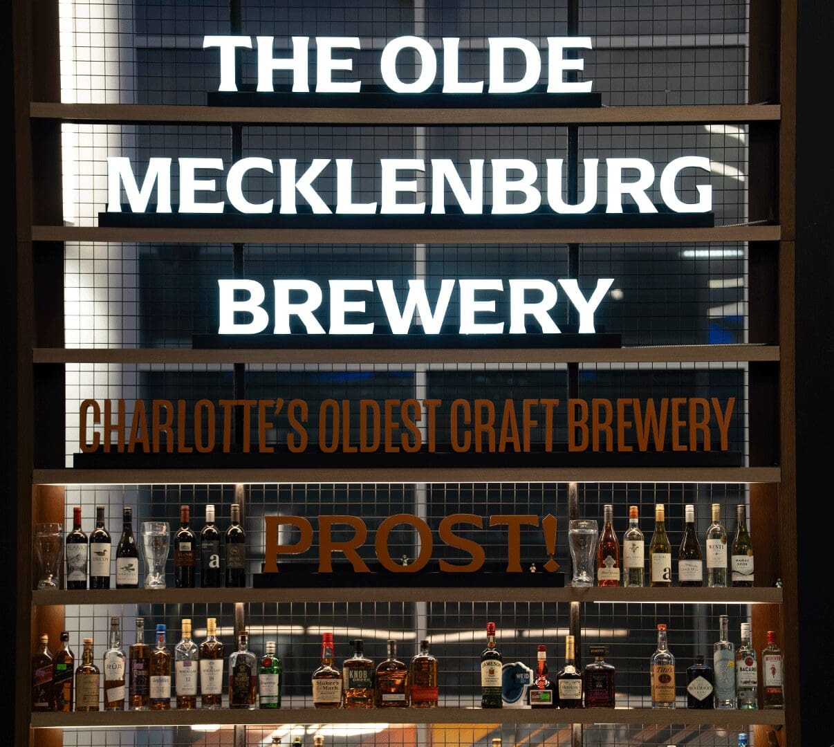Glowing Olde Mecklenburg Brewery sign above bottles